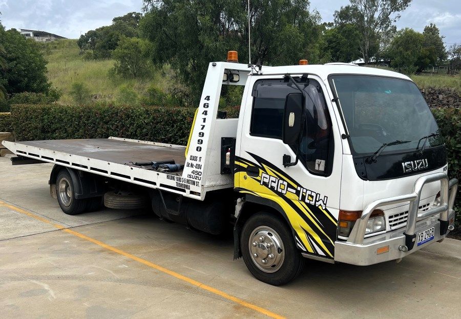 A White and Yellow Tow Truck is Parked in a Parking Lot — Pro-Tow Toowoomba in Wilsonton, QLD