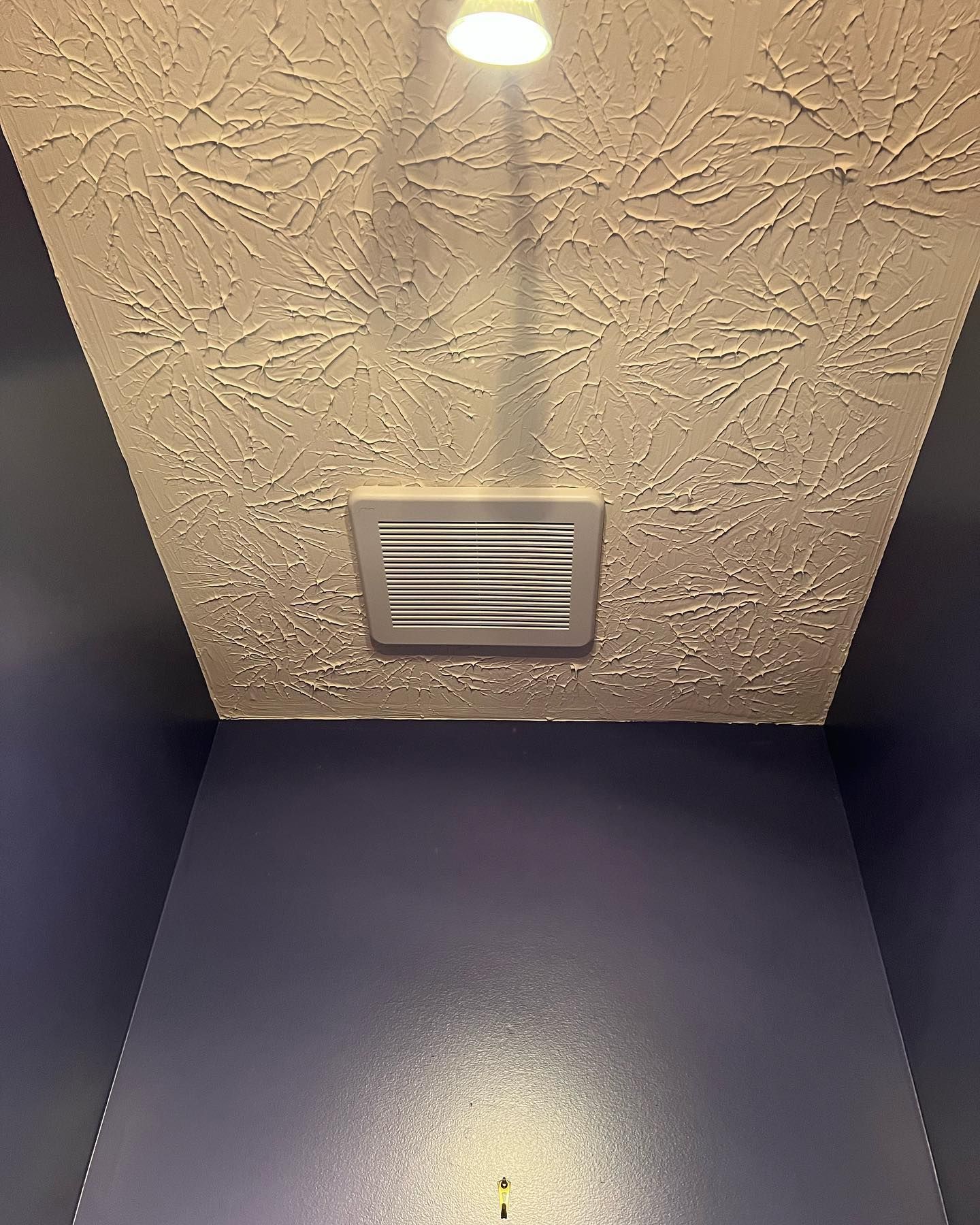 A ceiling fan is hanging from the ceiling of a room.