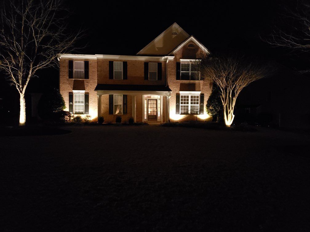 A large brick house is lit up at night