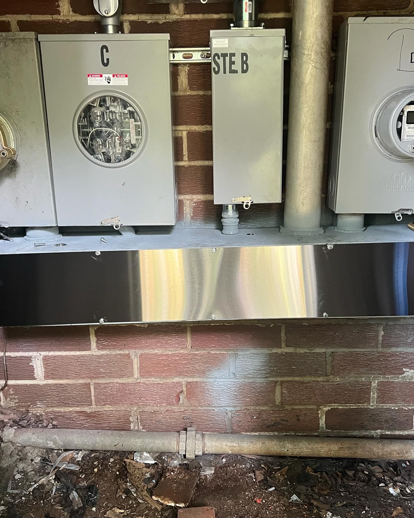 A brick wall with a bunch of electrical boxes on it