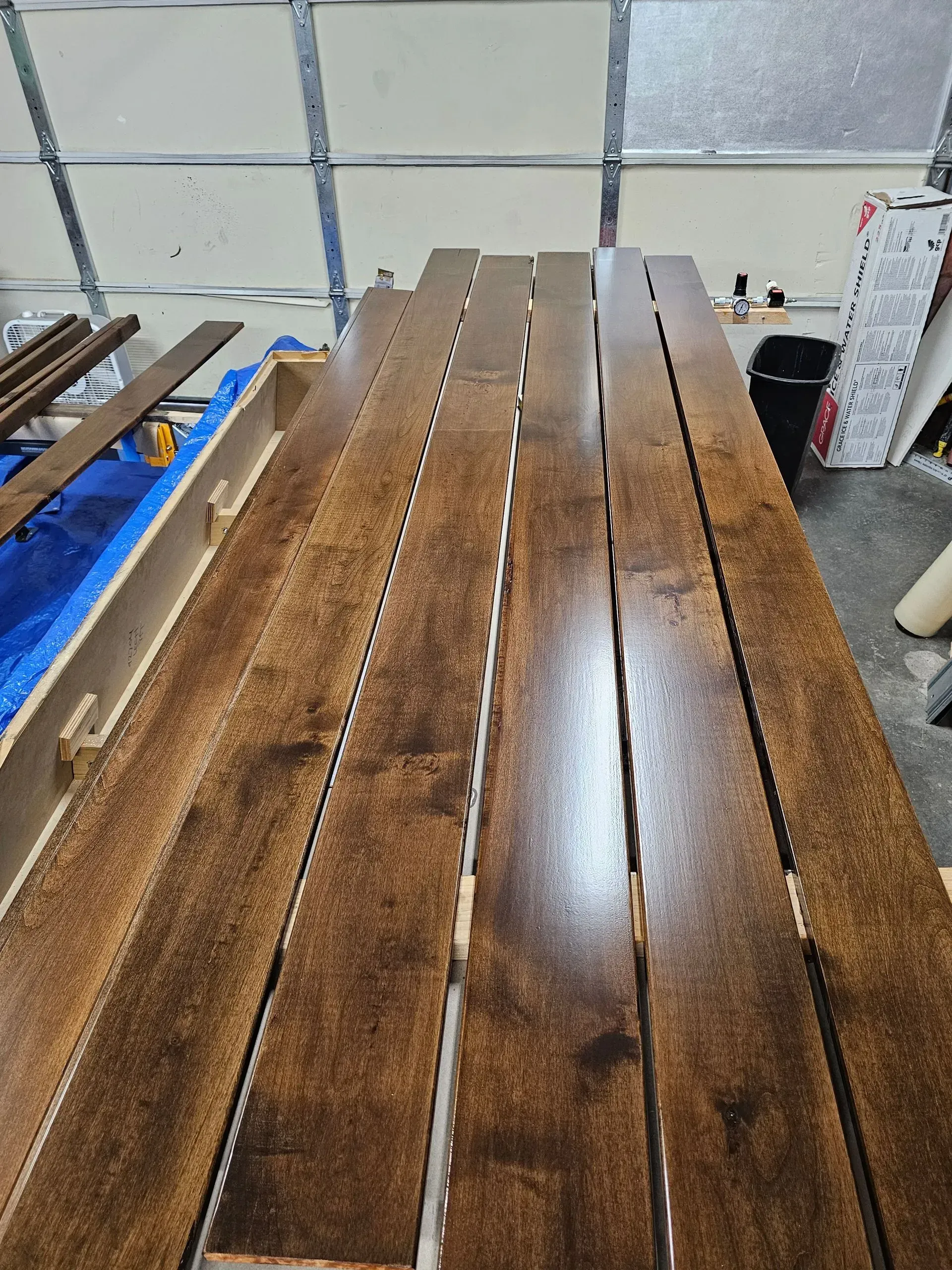A row of wooden boards sitting on top of each other in a garage.