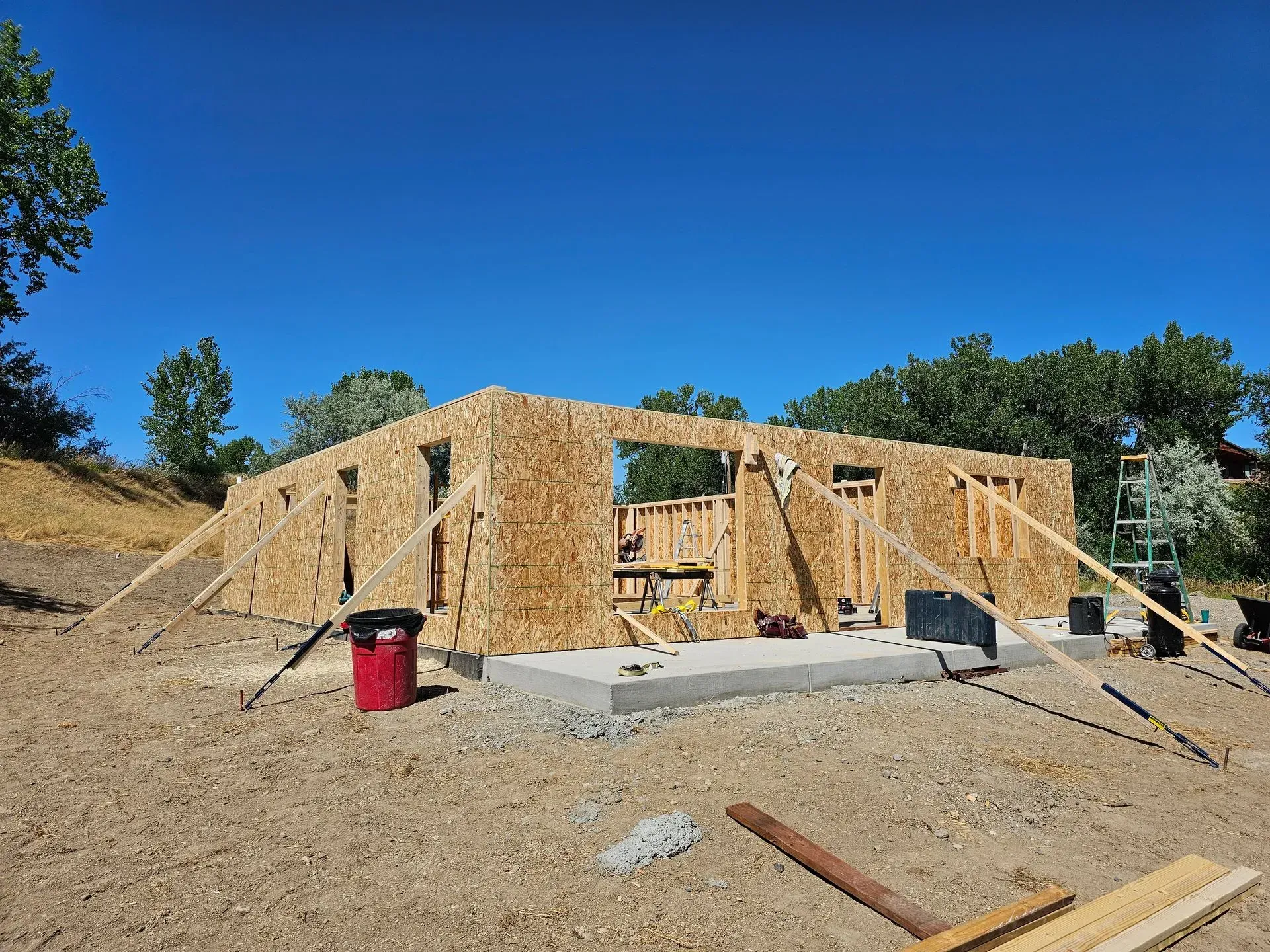 A house is being built in the middle of a dirt field.