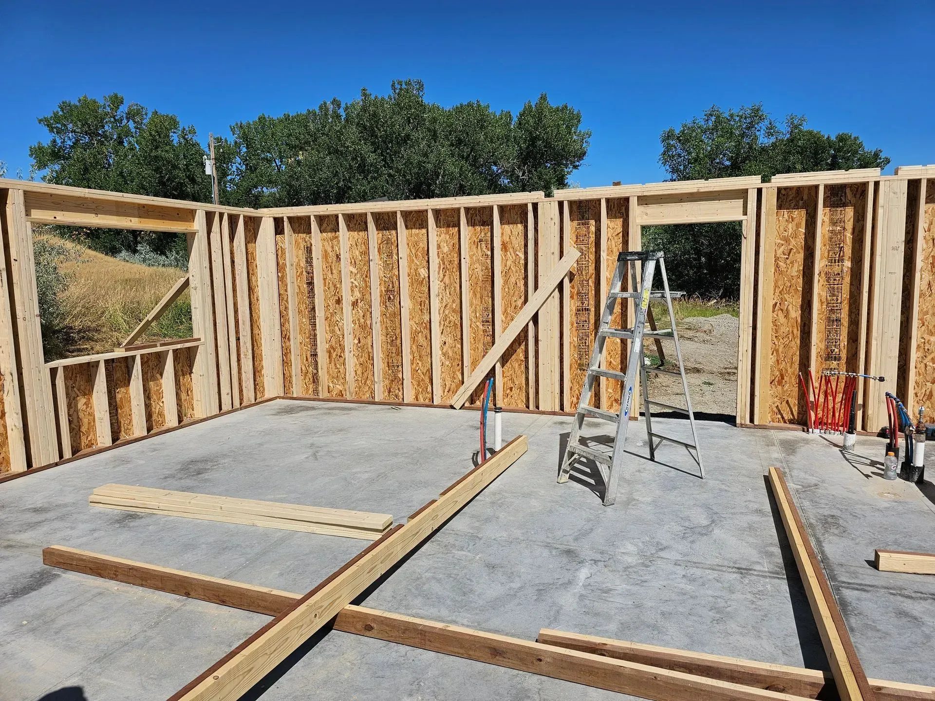 A house is being built with wooden walls and a ladder.