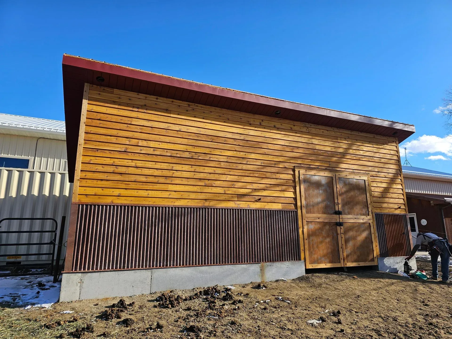 A horse is standing in front of a wooden building.