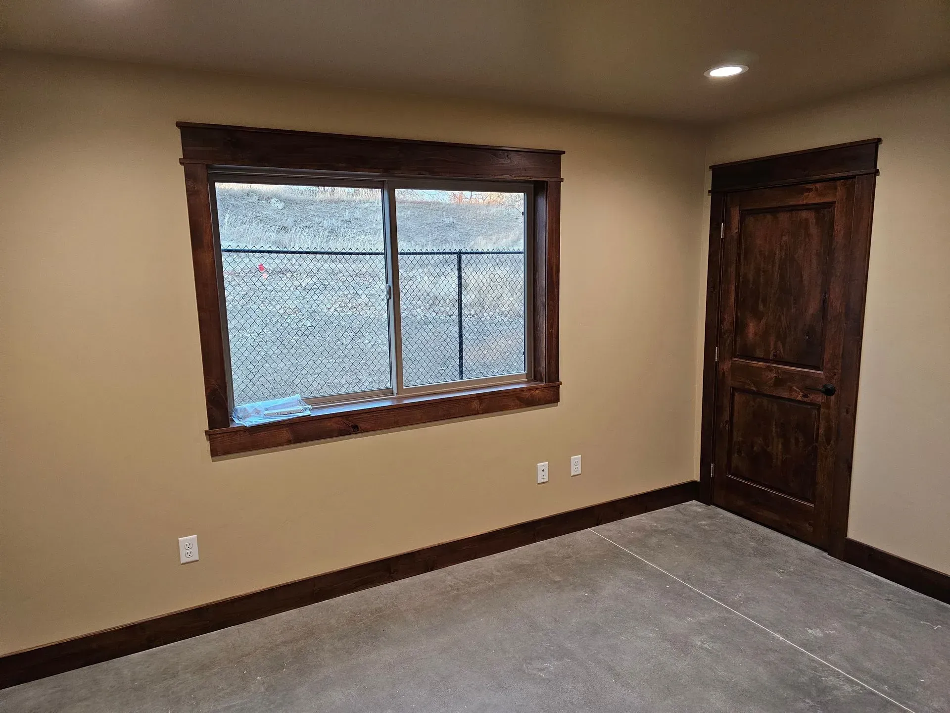 An empty room with a window and a door.
