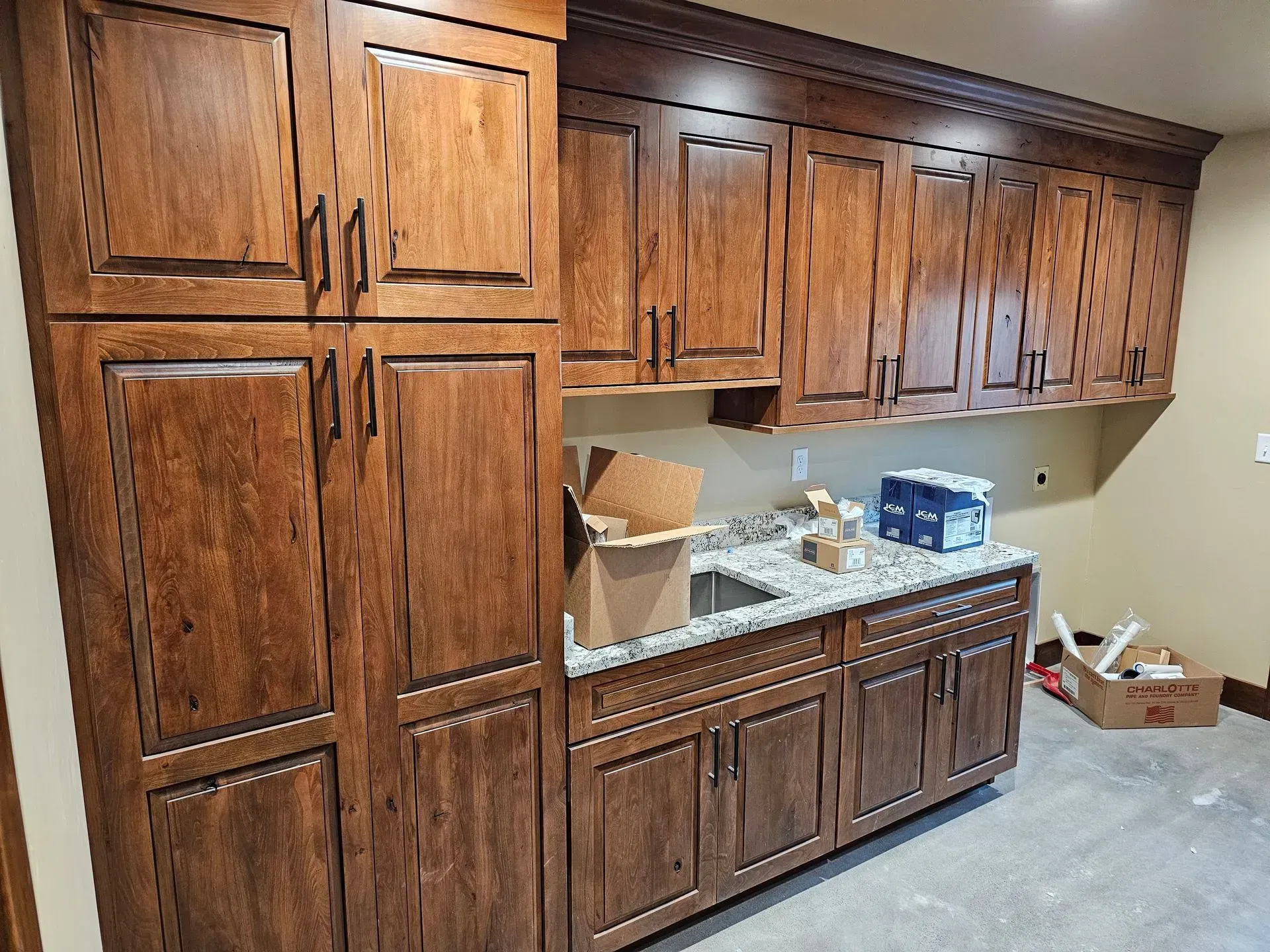 A kitchen with wooden cabinets and granite counter tops.