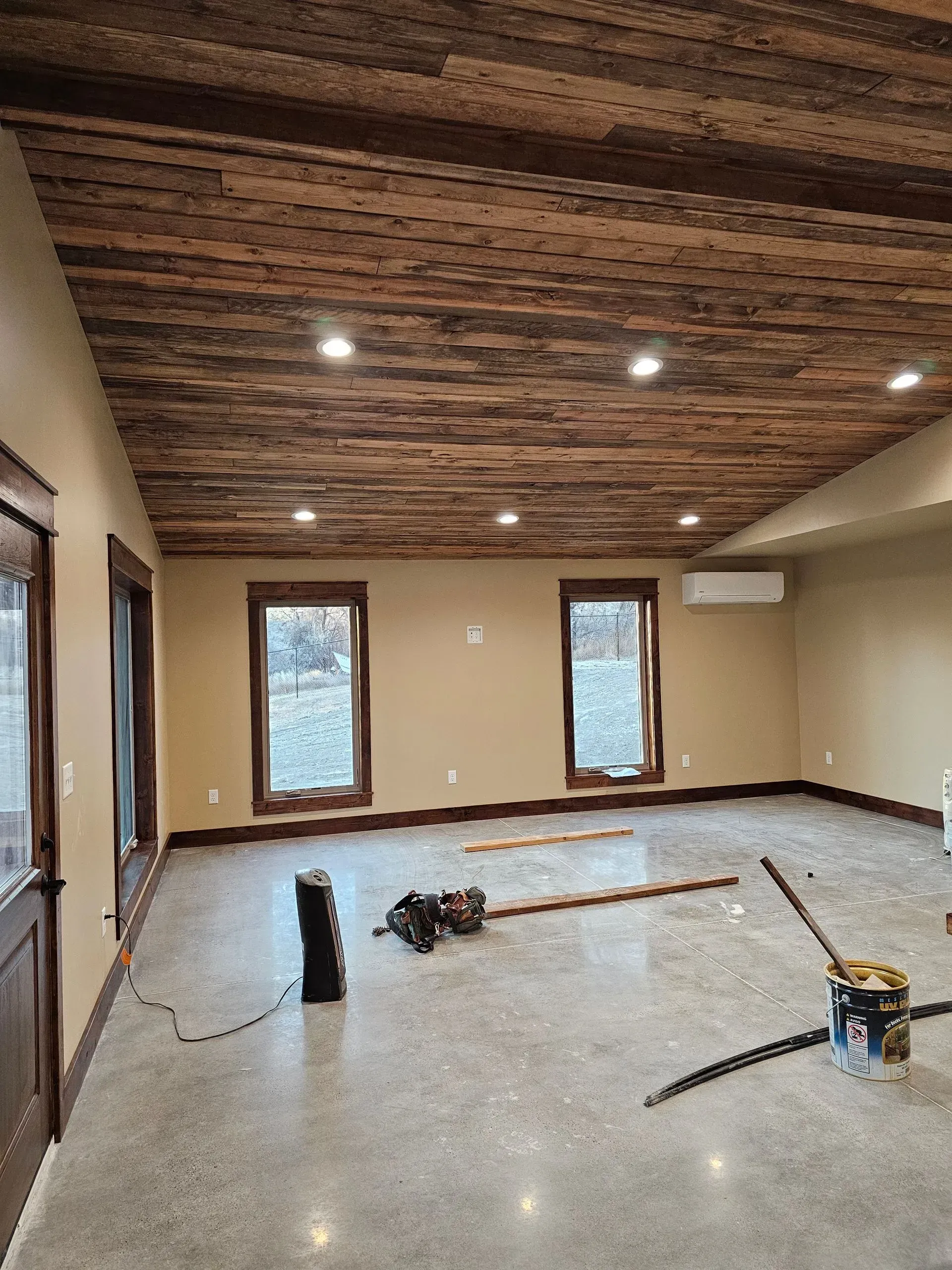 A large room with a wooden ceiling and concrete floor.