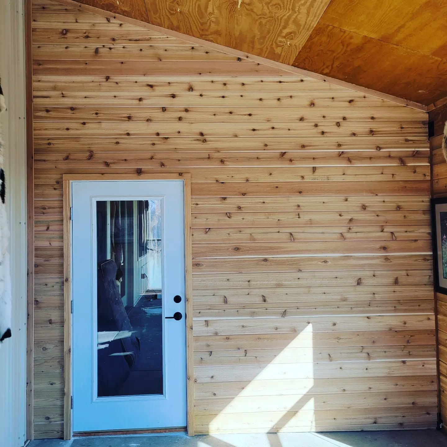 A room with a wooden wall and a white door
