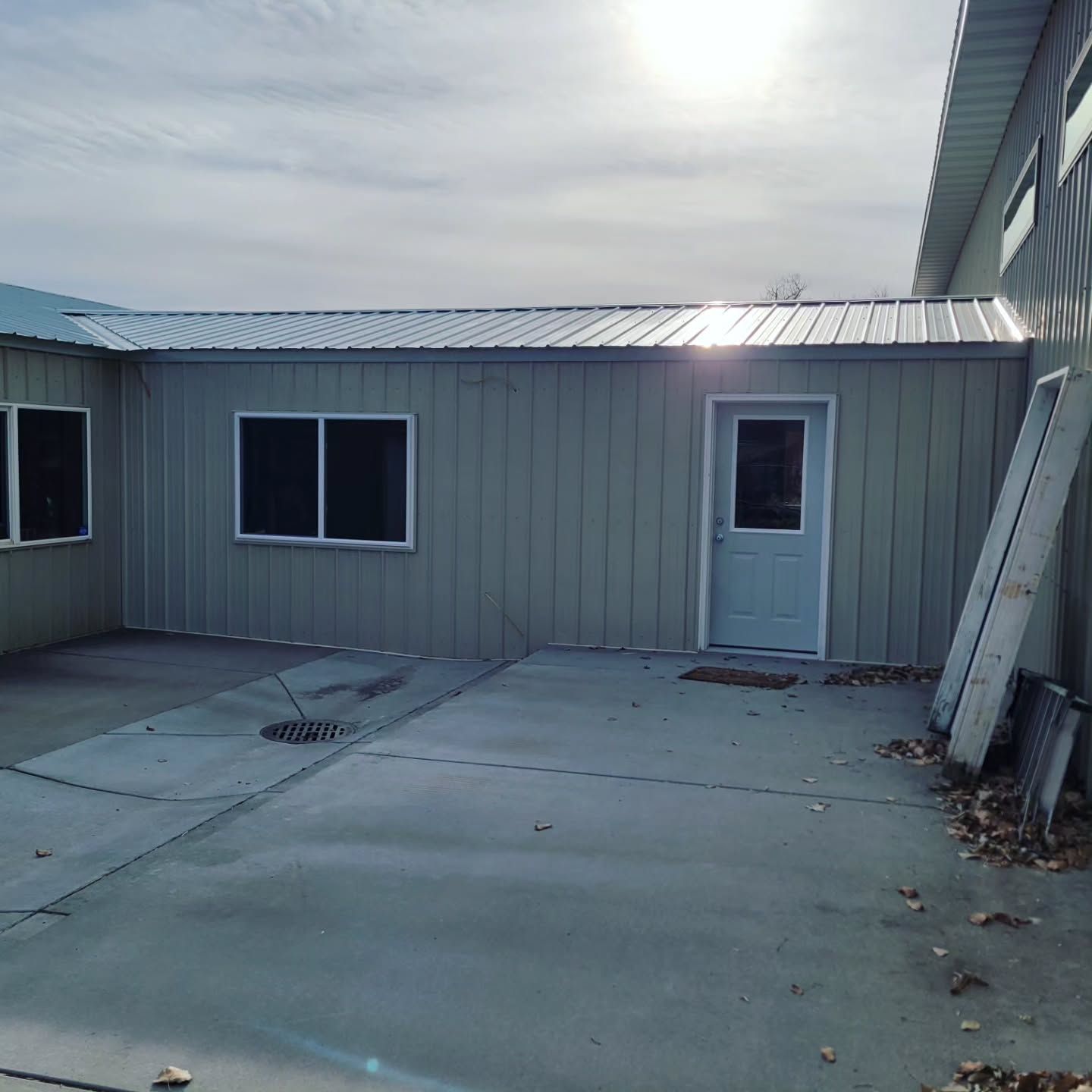 A gray building with a white door and windows