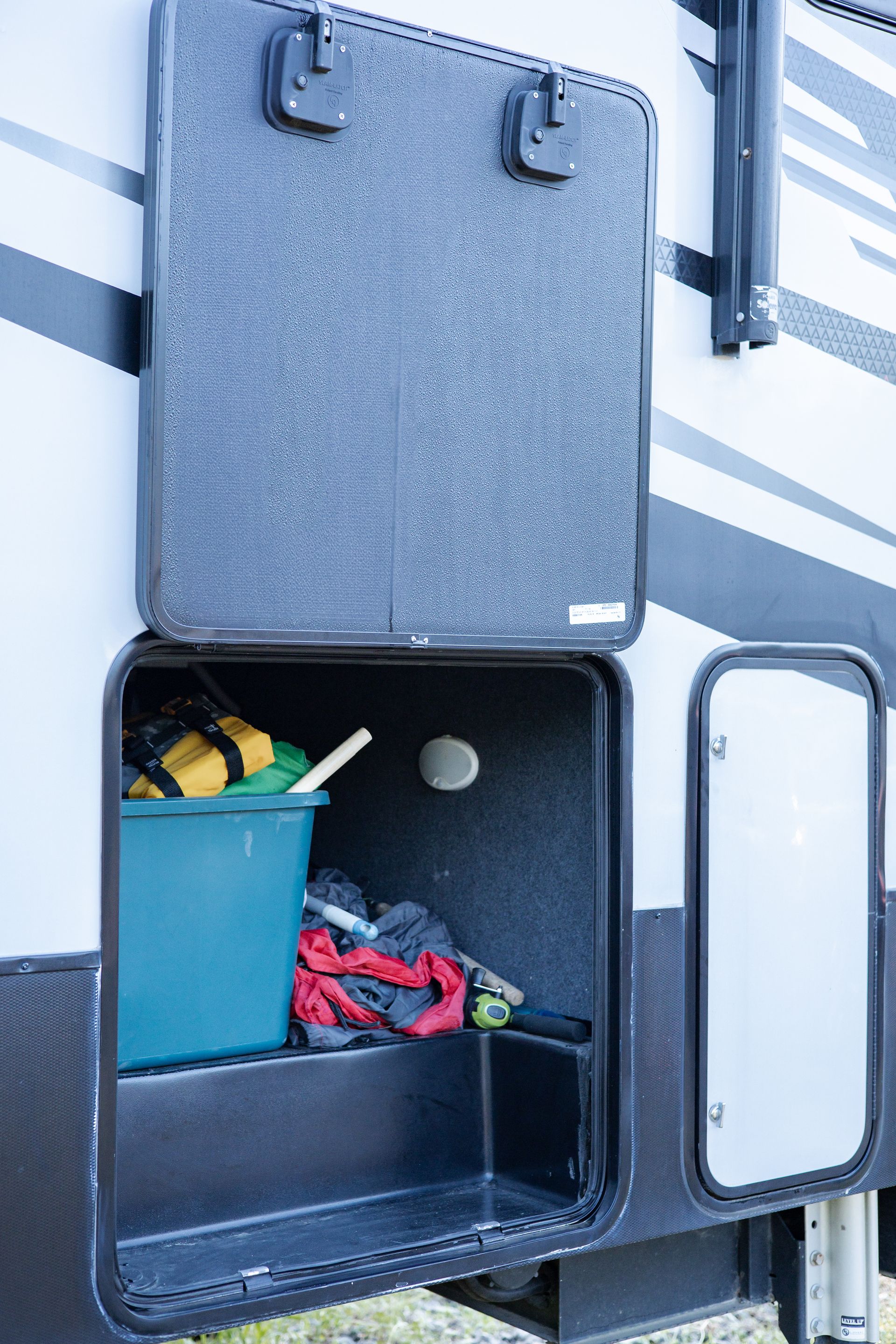 A rv with a blue bucket in the back of it.