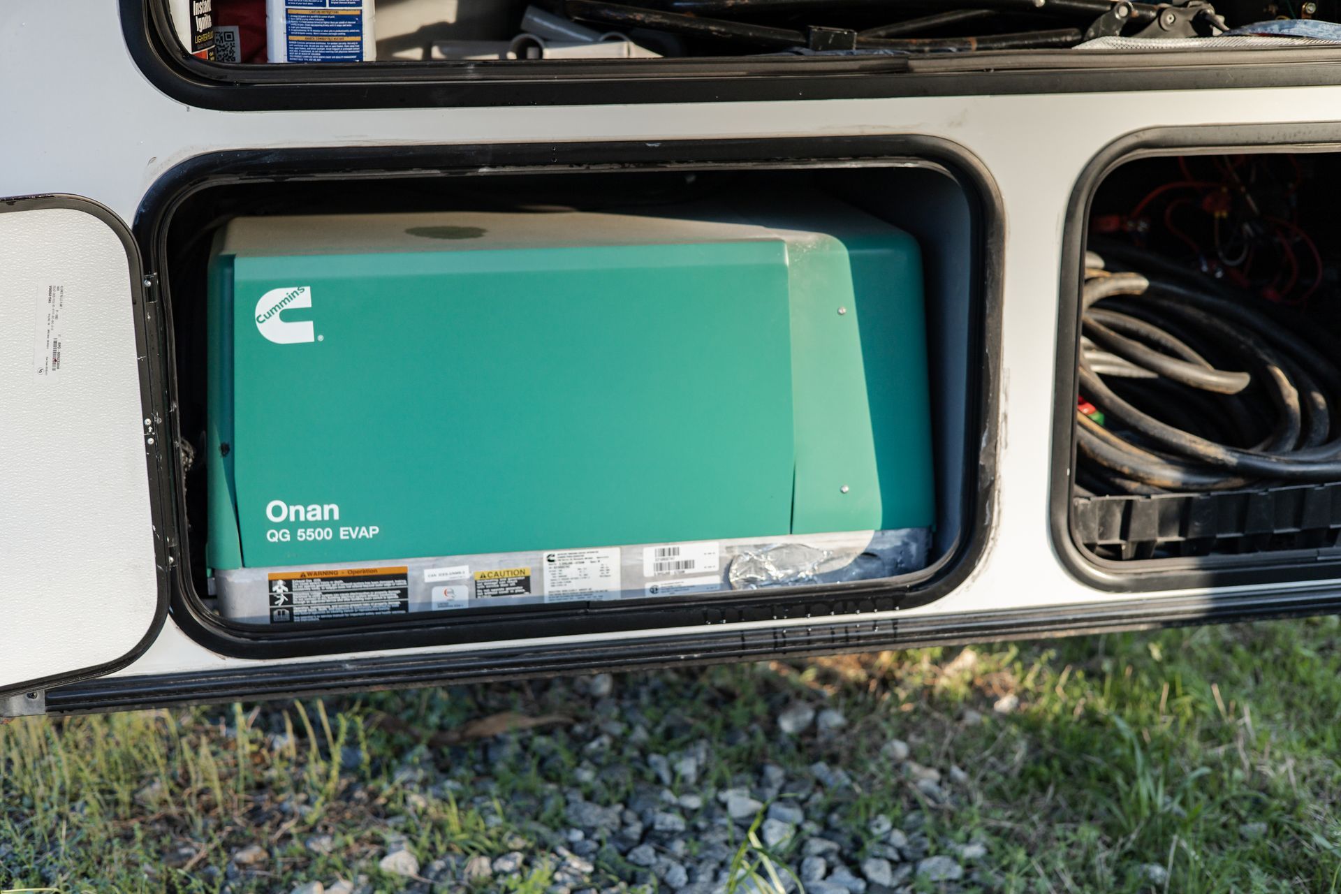A green generator is sitting in the back of a trailer.