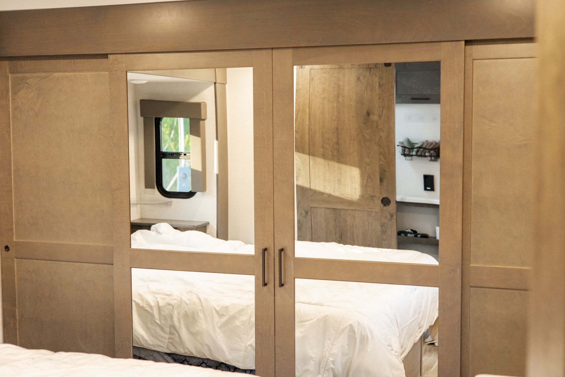 A bedroom with a bed and sliding glass doors with mirrors.