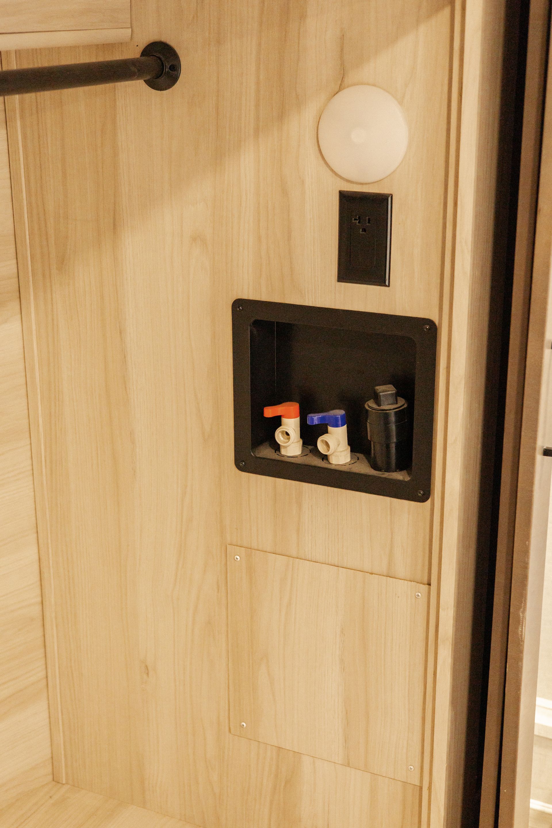 A bathroom with a shower and a shelf with bottles on it.