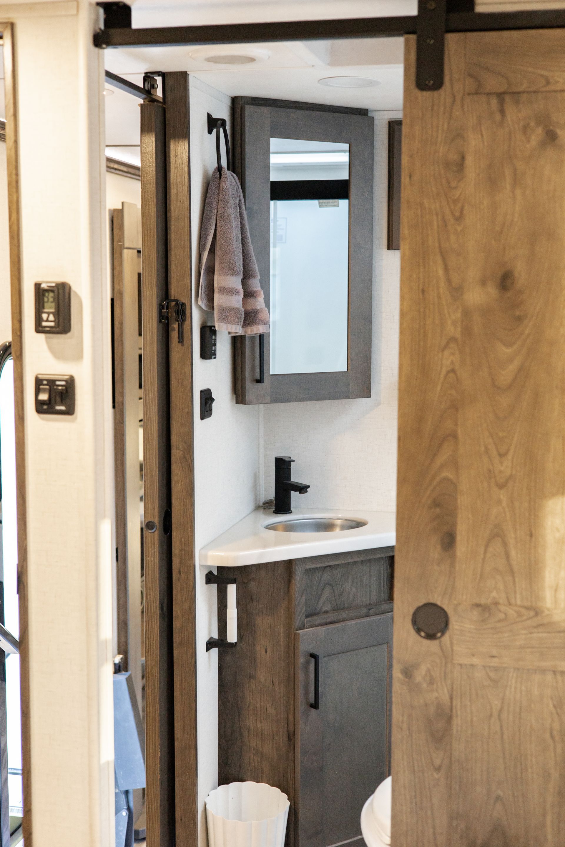 A bathroom with a sink , mirror and sliding barn door.