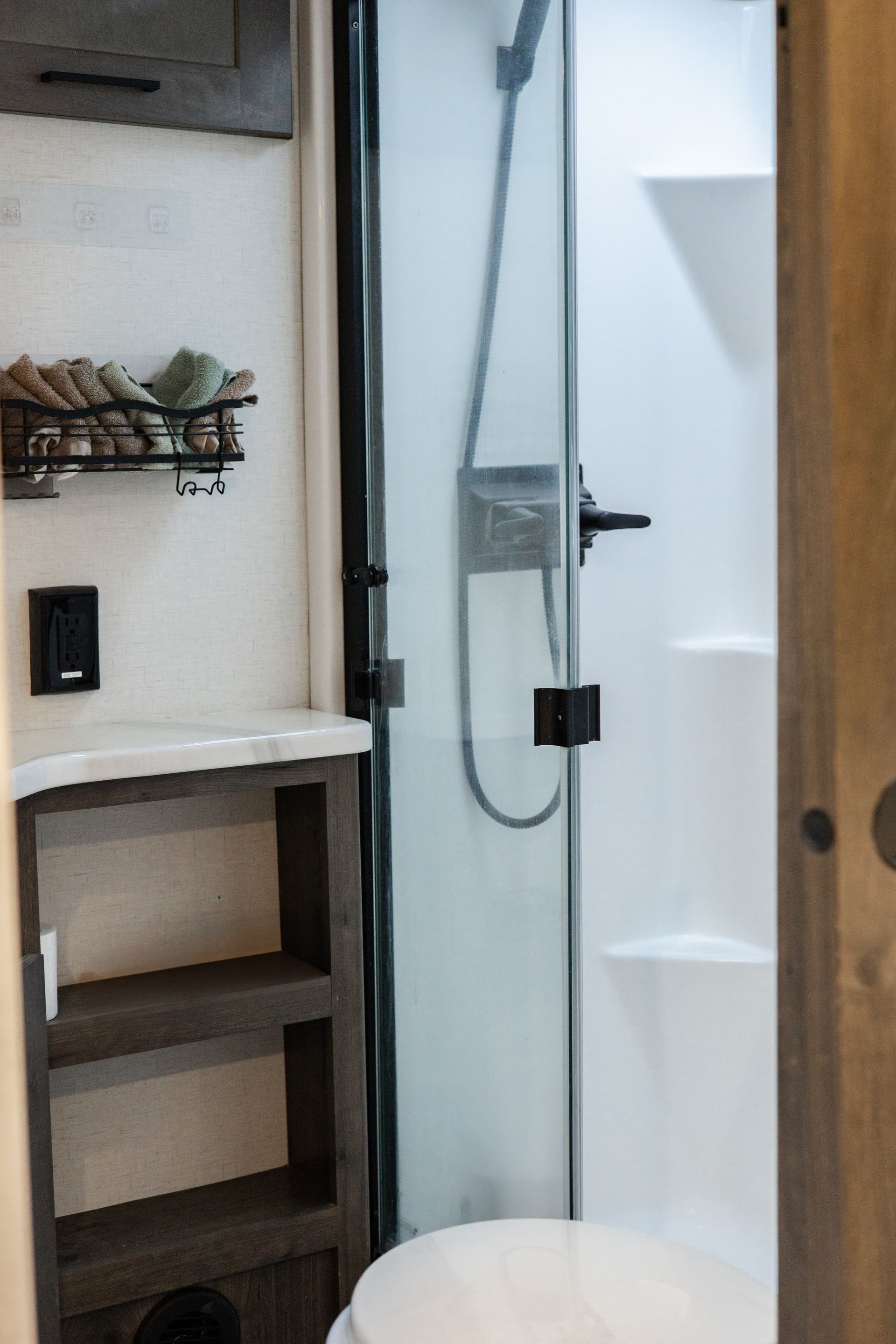 A bathroom with a toilet and a shower with a glass door.