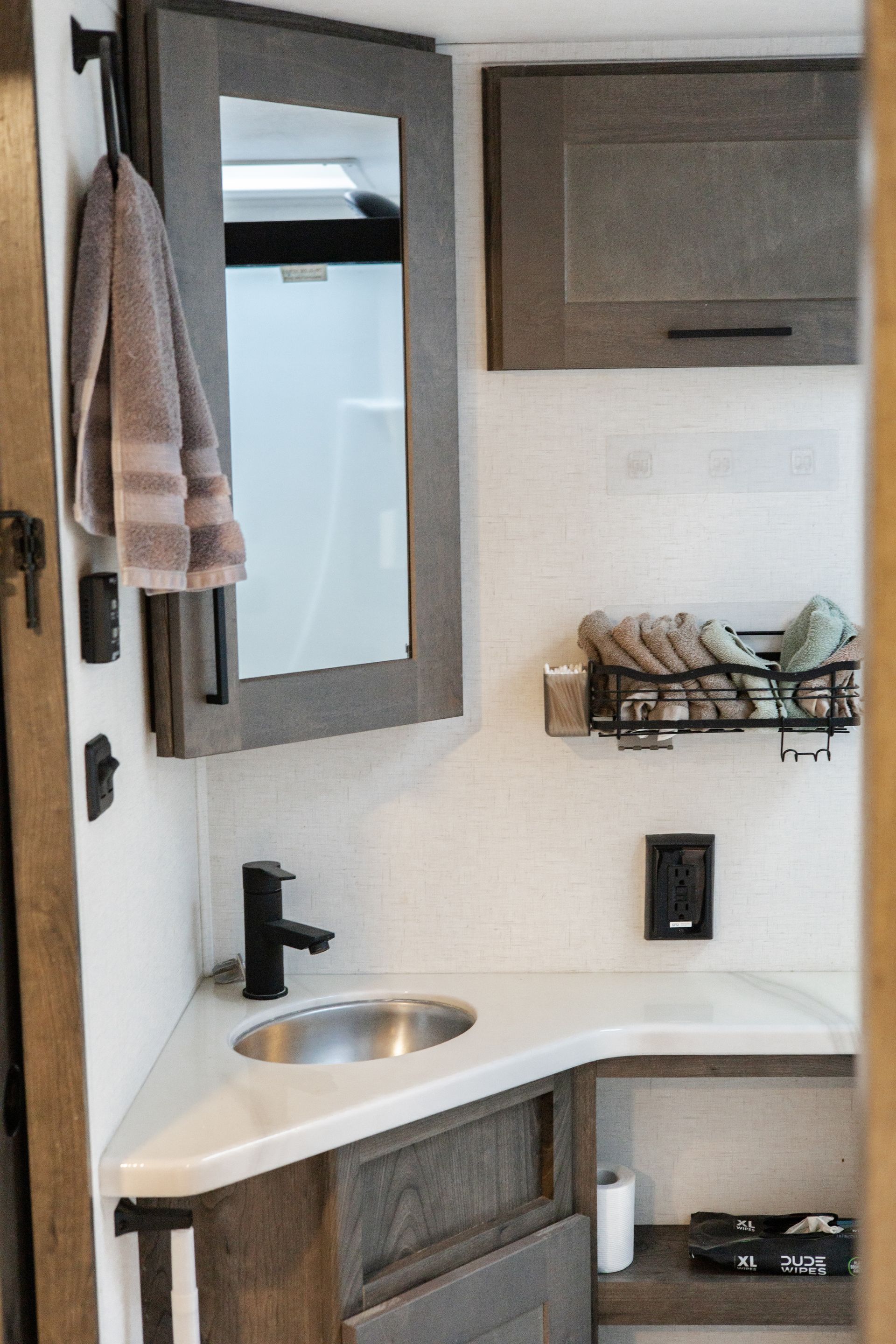 A bathroom with a sink , mirror , and cabinets.