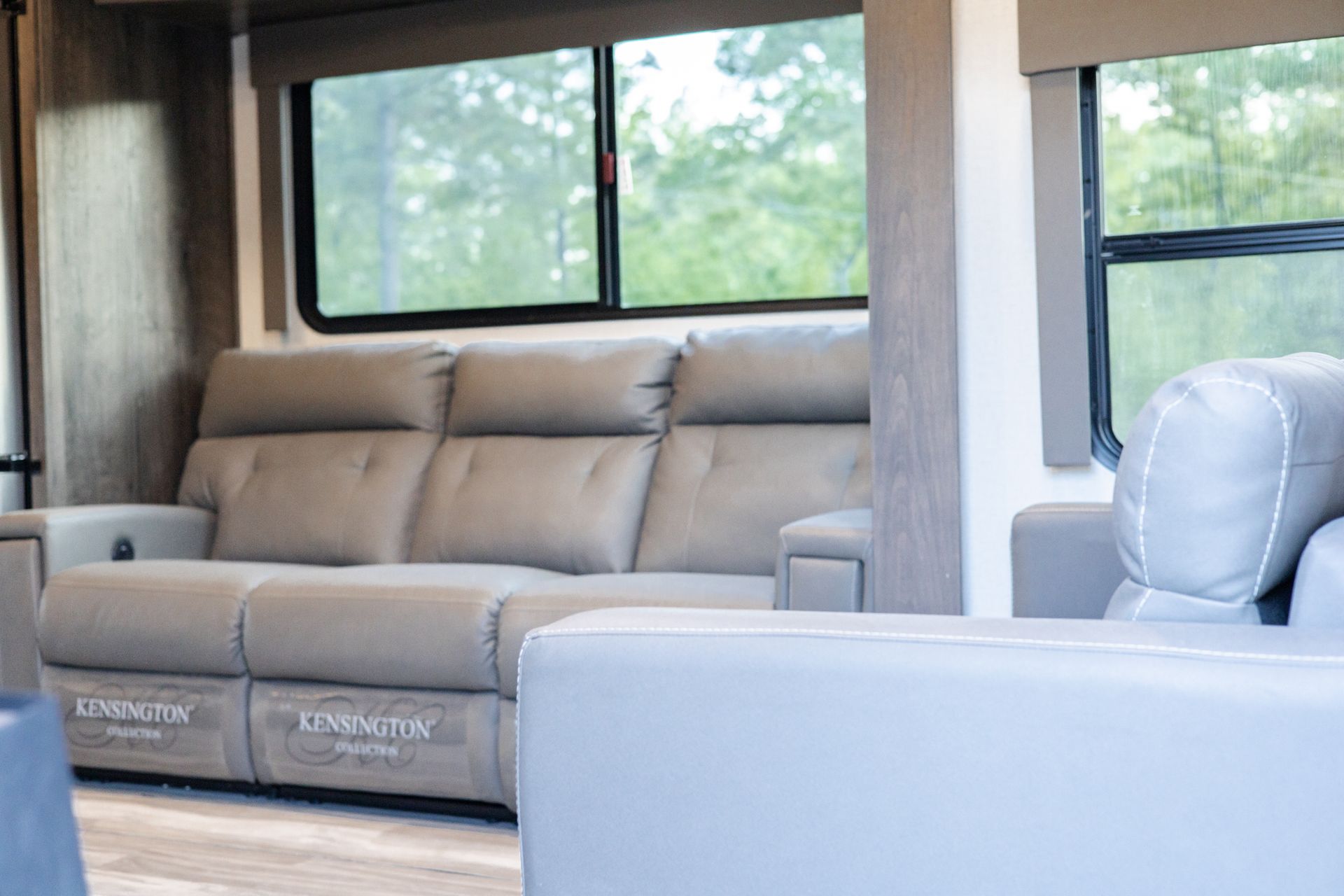 A living room with a couch , chair , and window.
