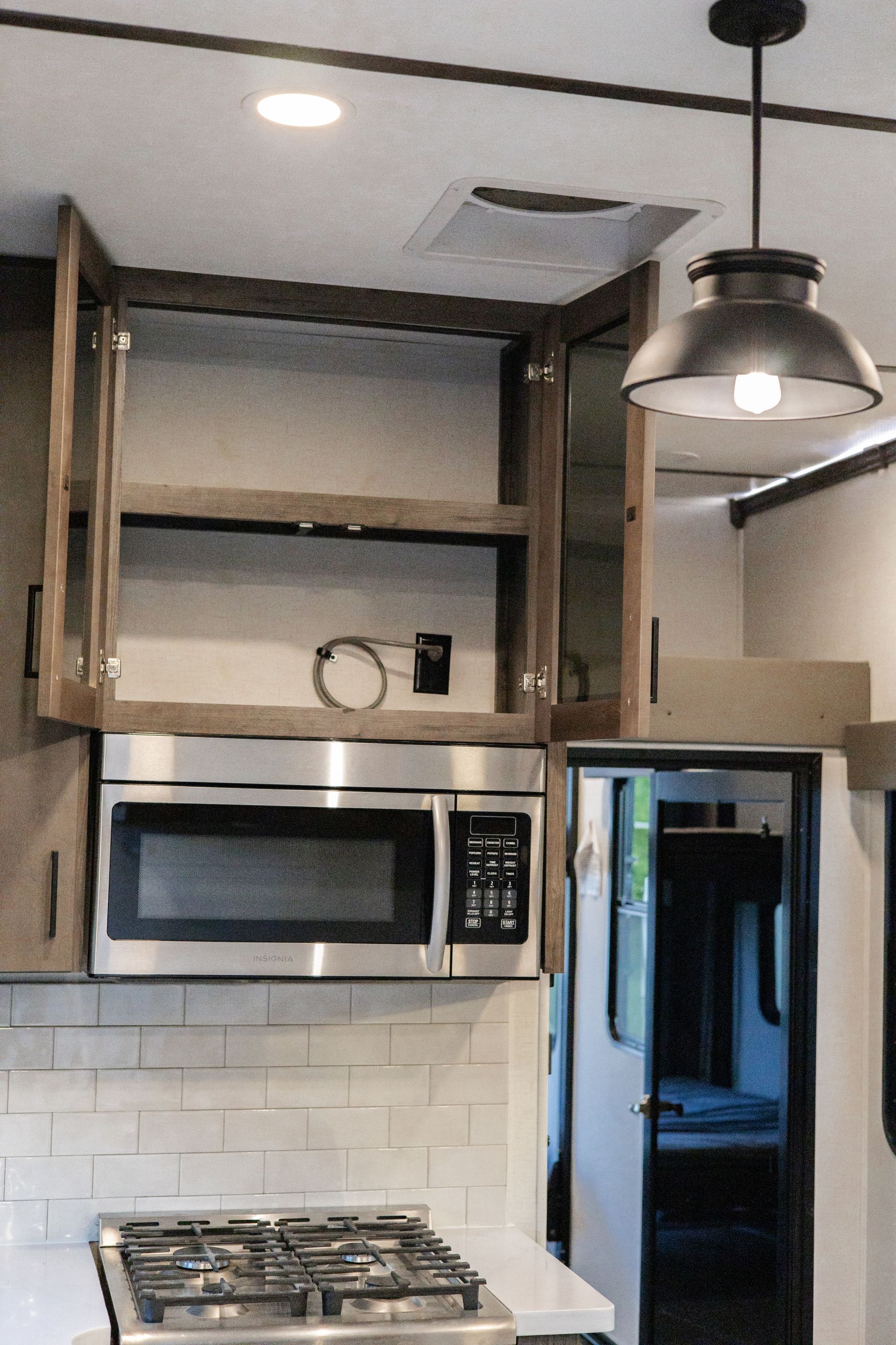 A kitchen with a stove top oven and a microwave
