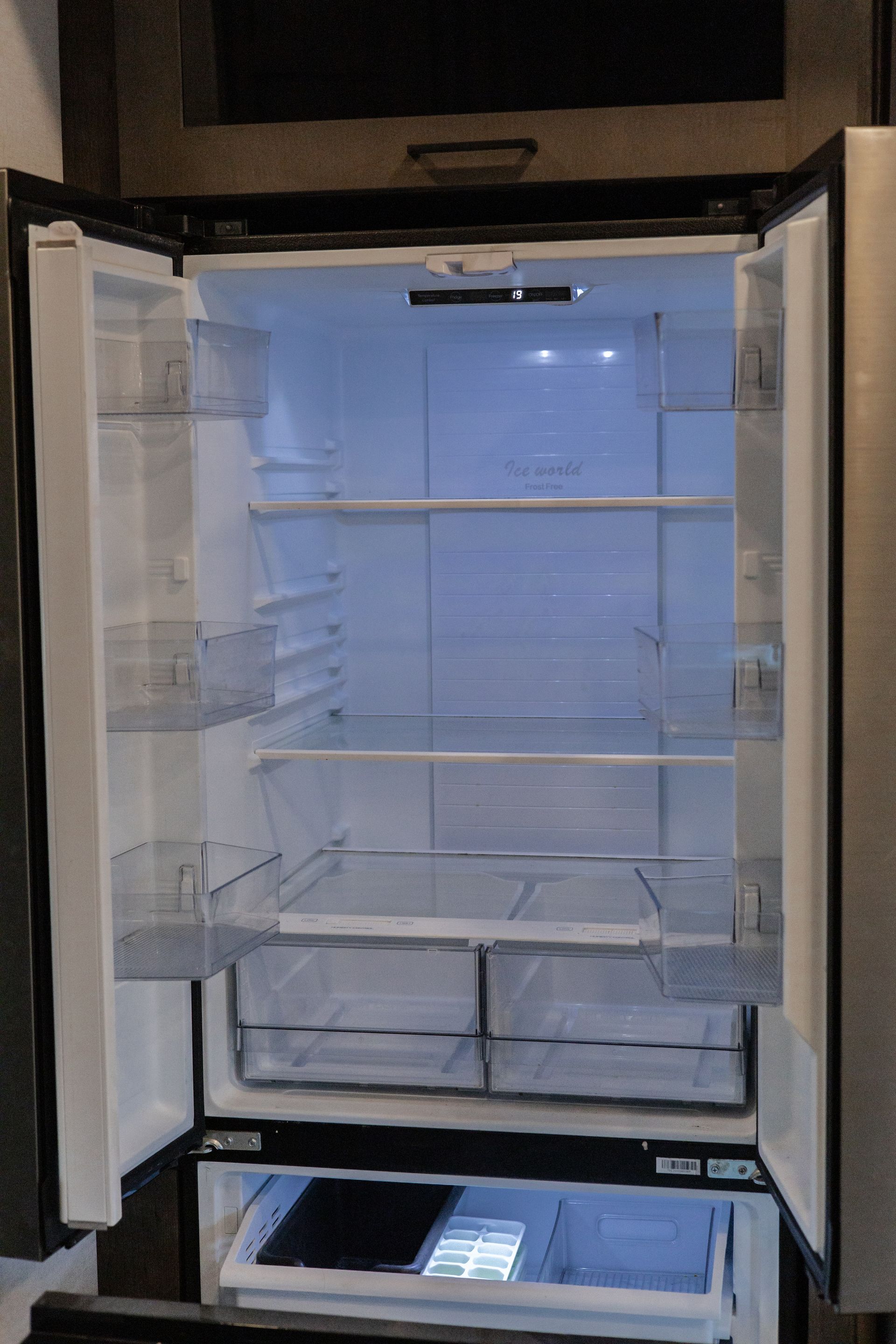 The inside of an empty refrigerator with the door open.