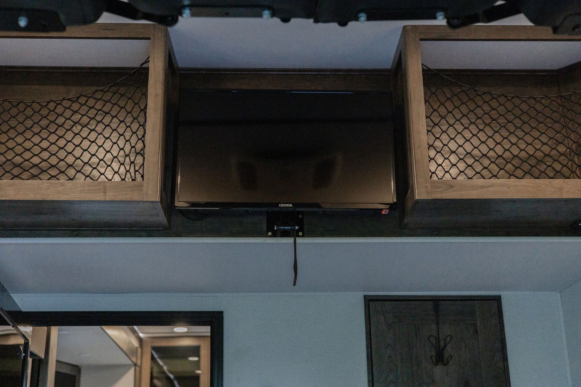 A tv is hanging from the ceiling in a room.