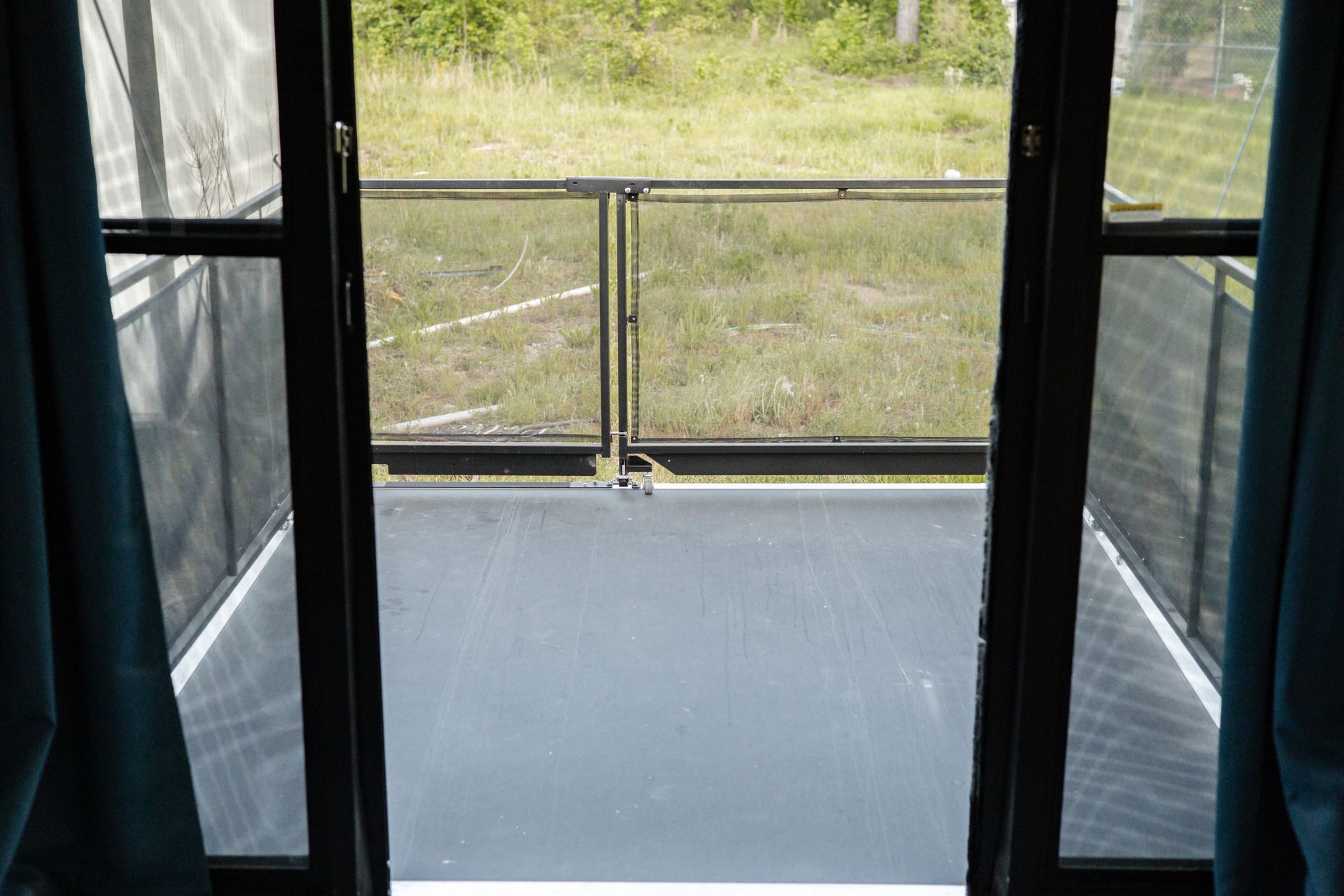 A view of a balcony through a screen door.