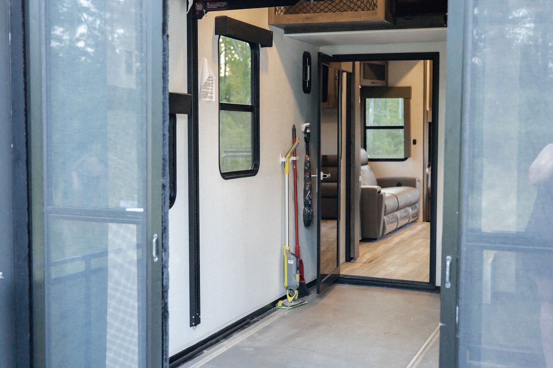 A rv is parked in a garage with a screen door.