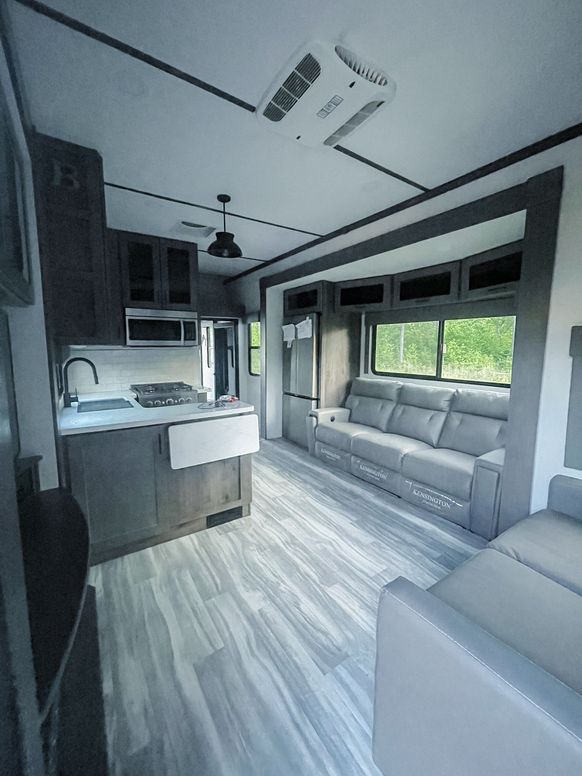 A living room with a couch and a kitchen