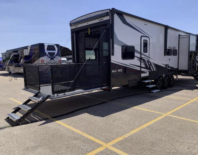 A white and black trailer is parked in a parking lot.