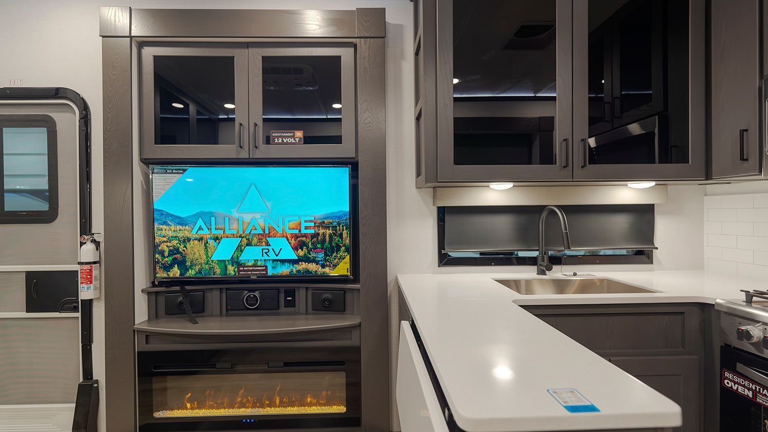 A kitchen with a fireplace and a flat screen tv.