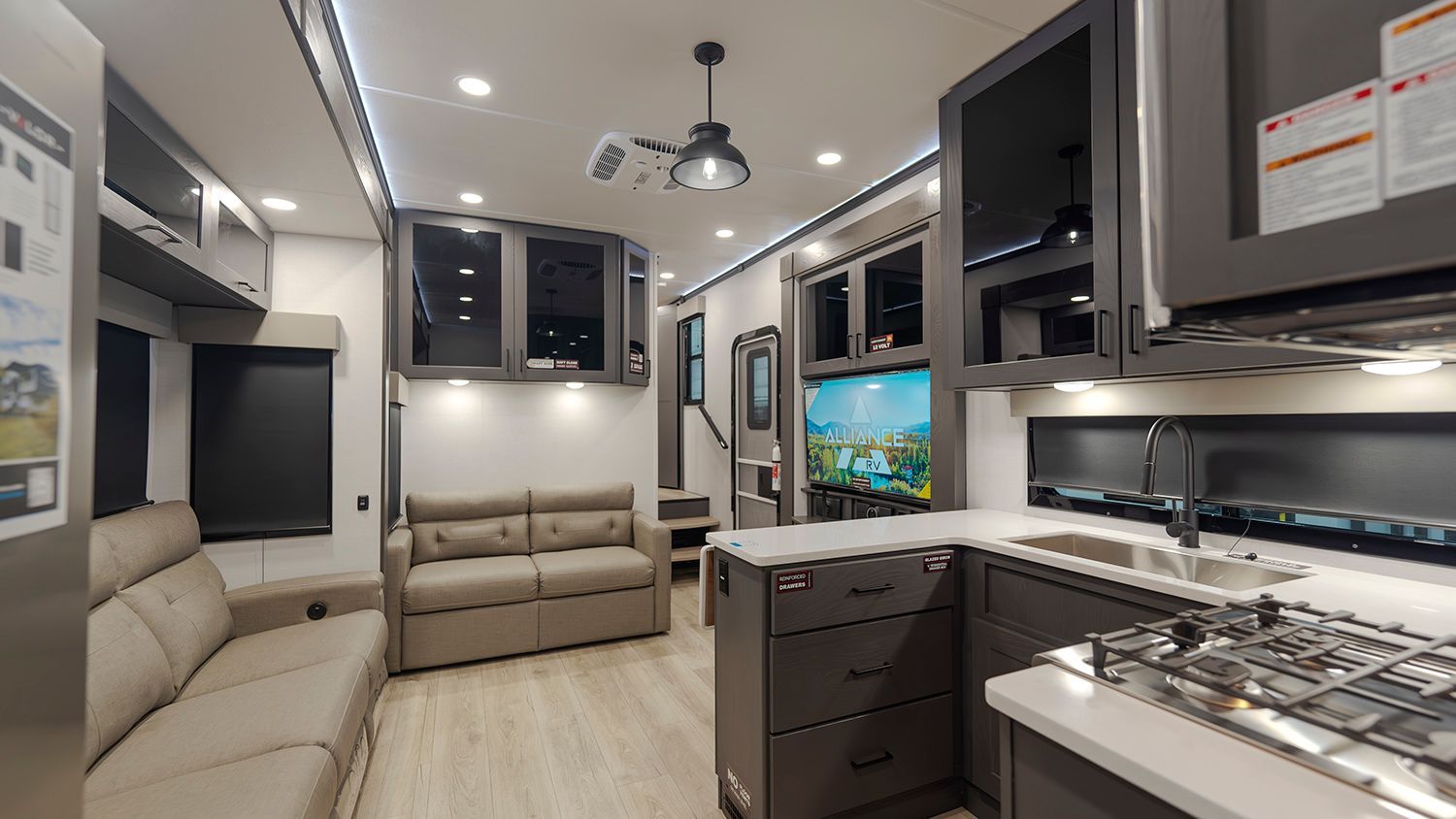 A living room with a couch and a kitchen in a rv.