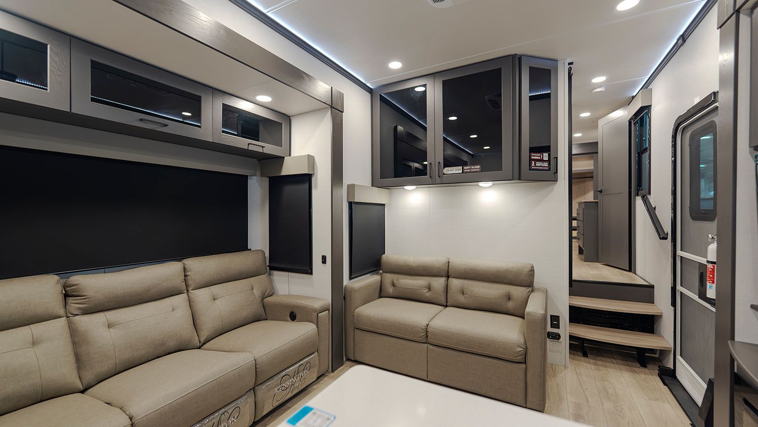 A living room in a rv with a couch and stairs.