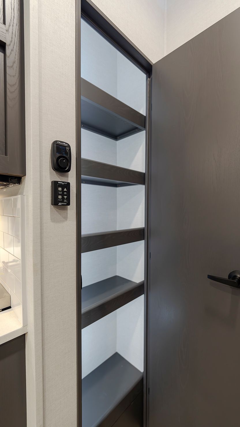 A pantry with shelves and a door in a kitchen.