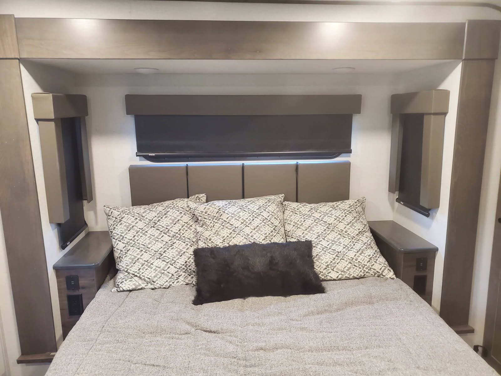 A bed with pillows and a headboard in a rv