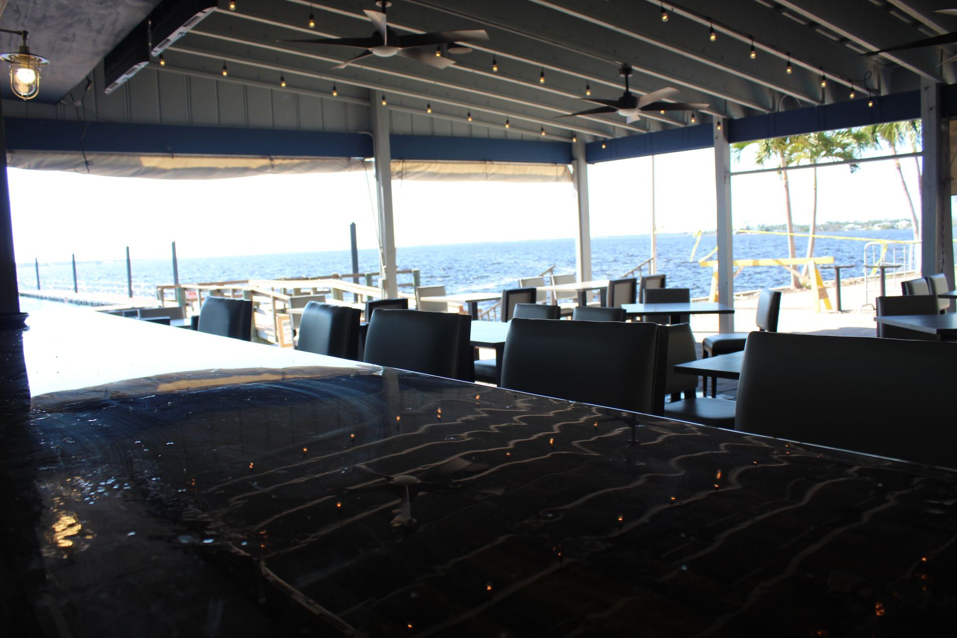 A restaurant with tables and chairs overlooking the ocean