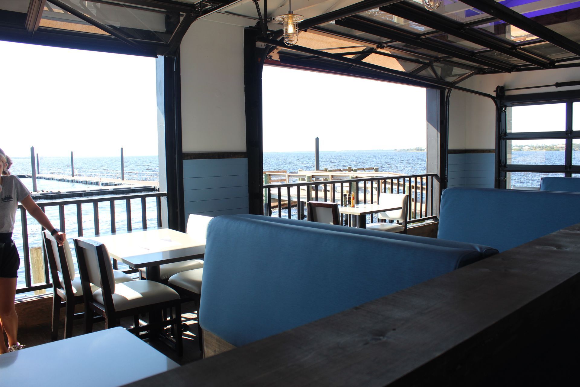 A restaurant with tables and chairs and a view of the ocean