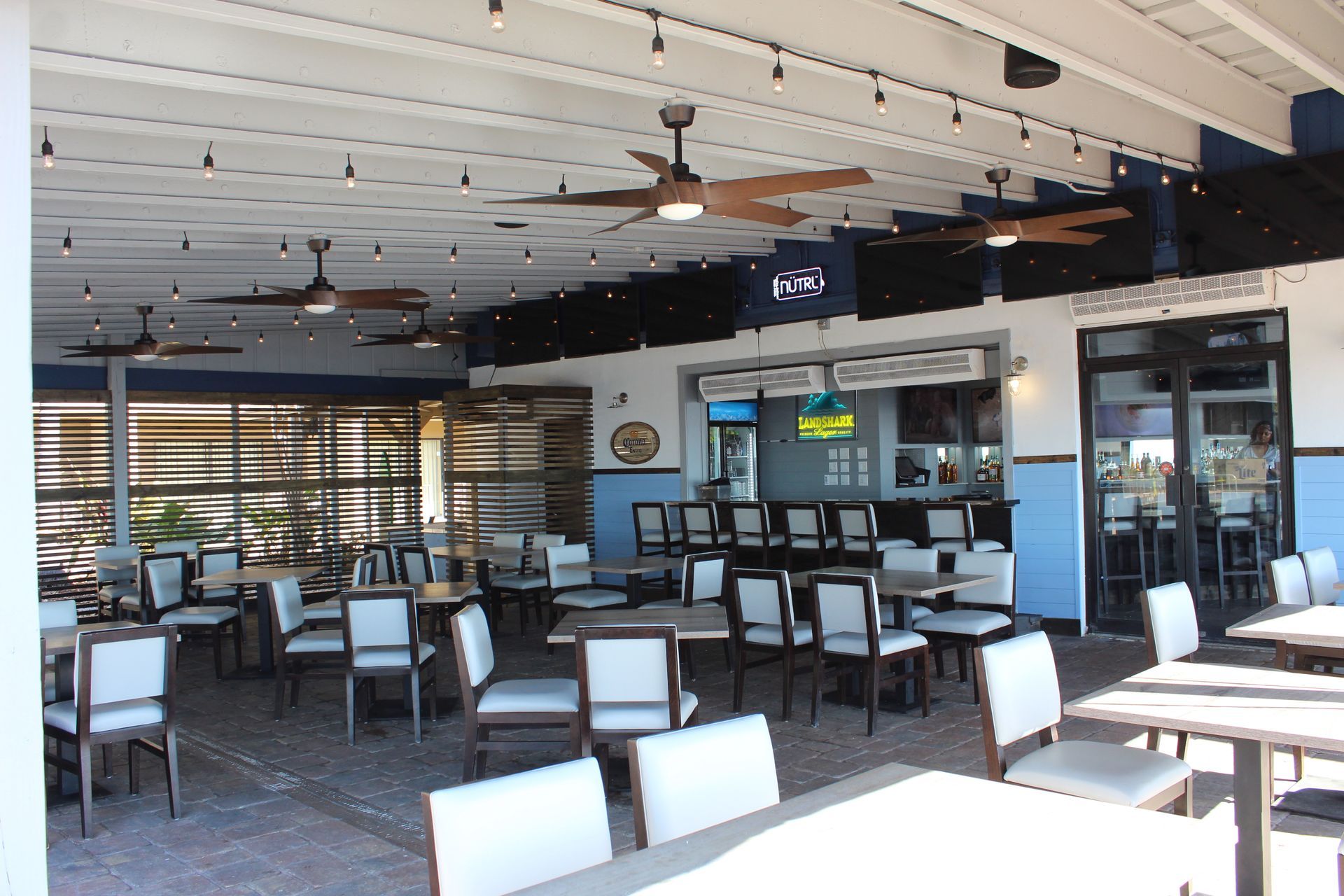 A restaurant with tables and chairs and ceiling fans