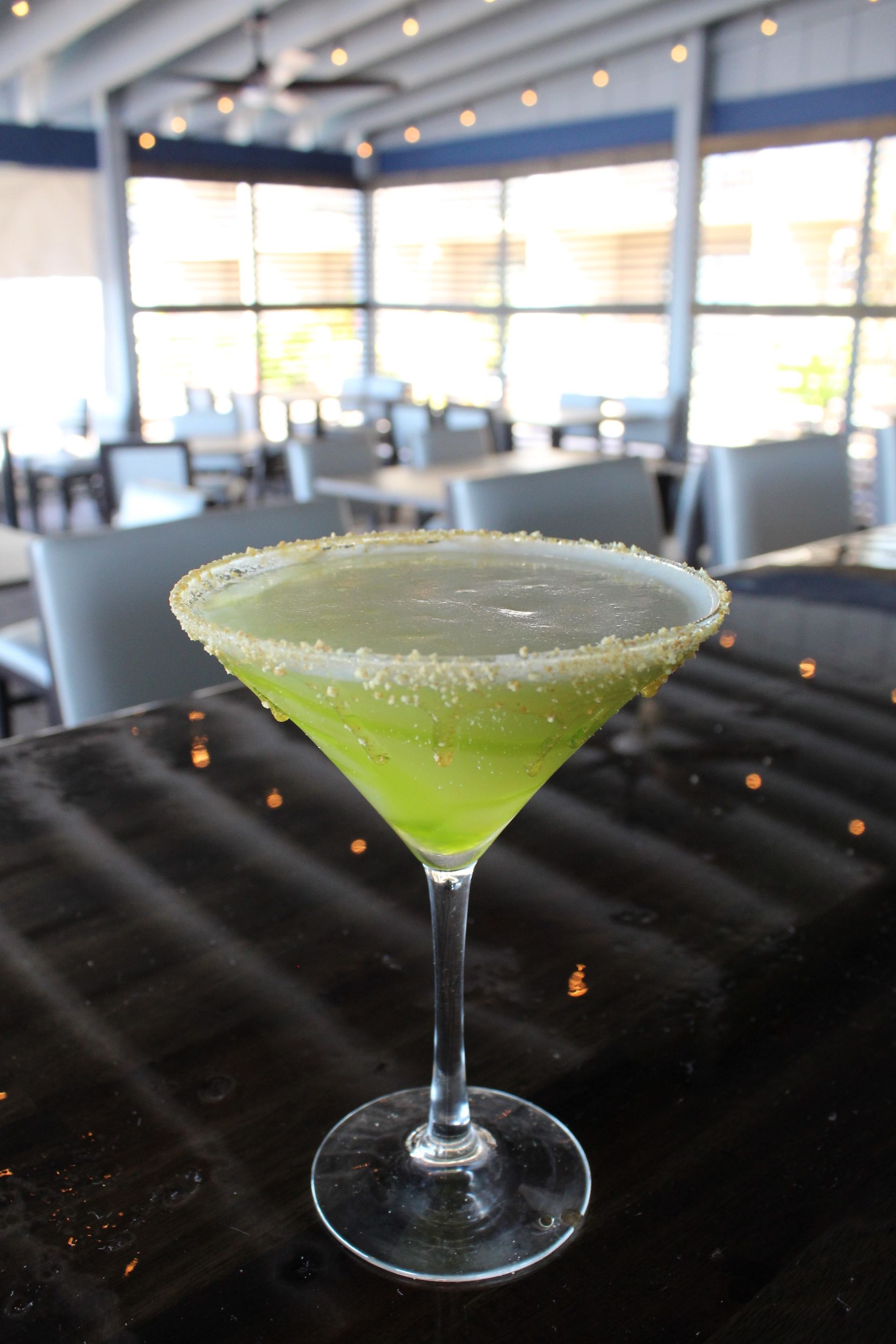 A martini glass with a green liquid in it