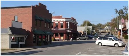 A white van is parked in front of a brick building