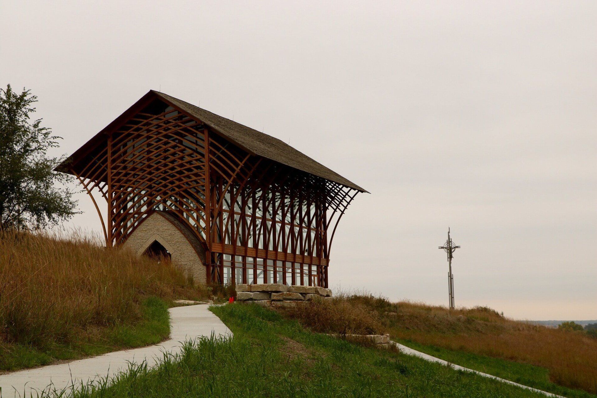 A wooden structure is sitting on top of a grassy hill.