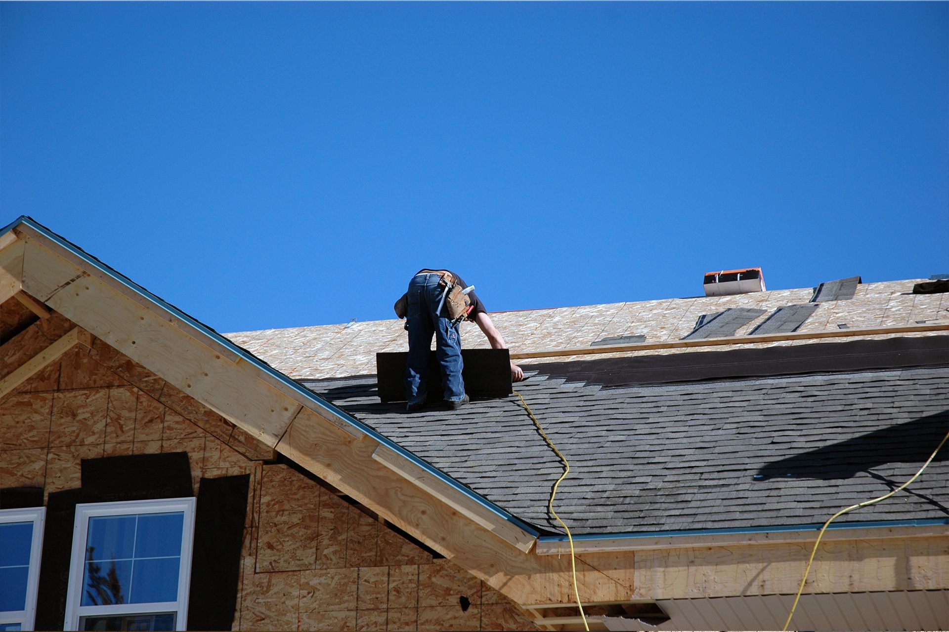 A roofer installing a new roof in a residential home.