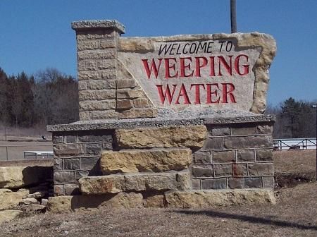 A stone sign that says welcome to weeping water
