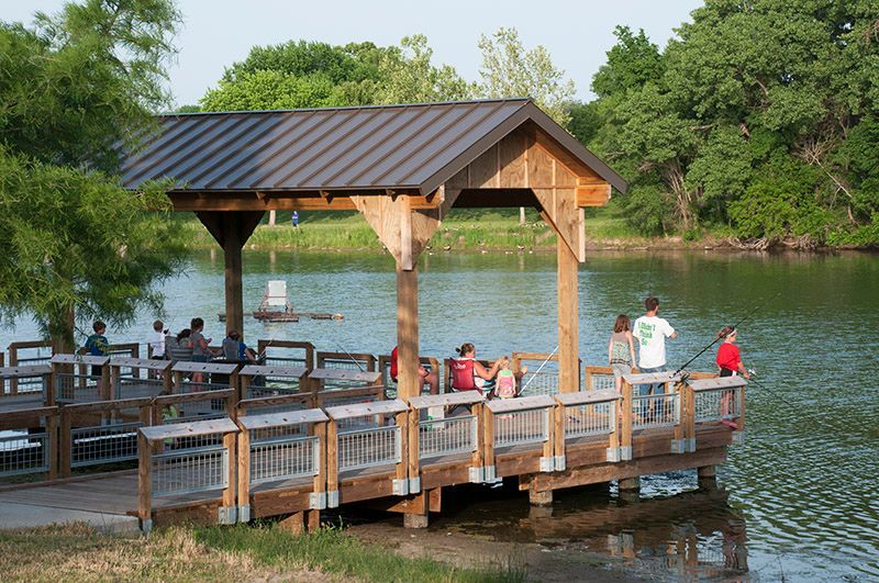 A group of people sitting on a dock overlooking a lake