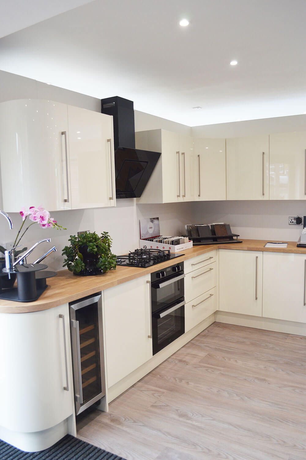 A kitchen with white cabinets and wooden counter tops