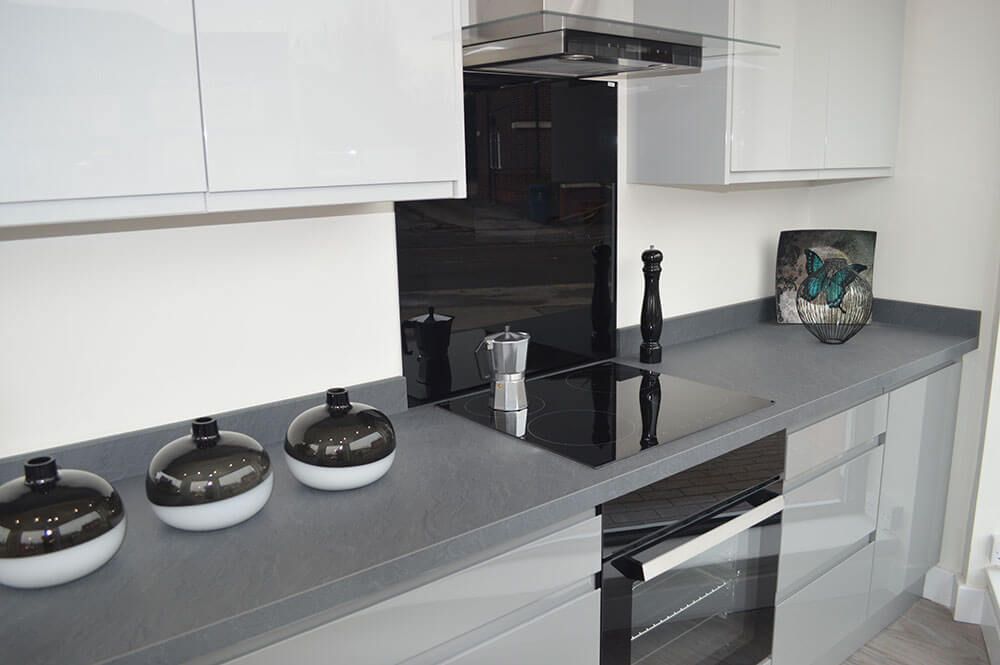 A kitchen with a black stove top oven and white cabinets.
