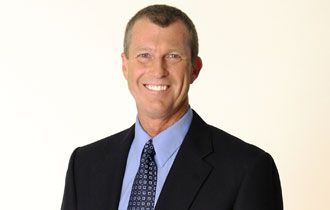 Dr. John H. Sklare of The Inner Diet in a suit smiling, with blue shirt and tie against a cream colored background.