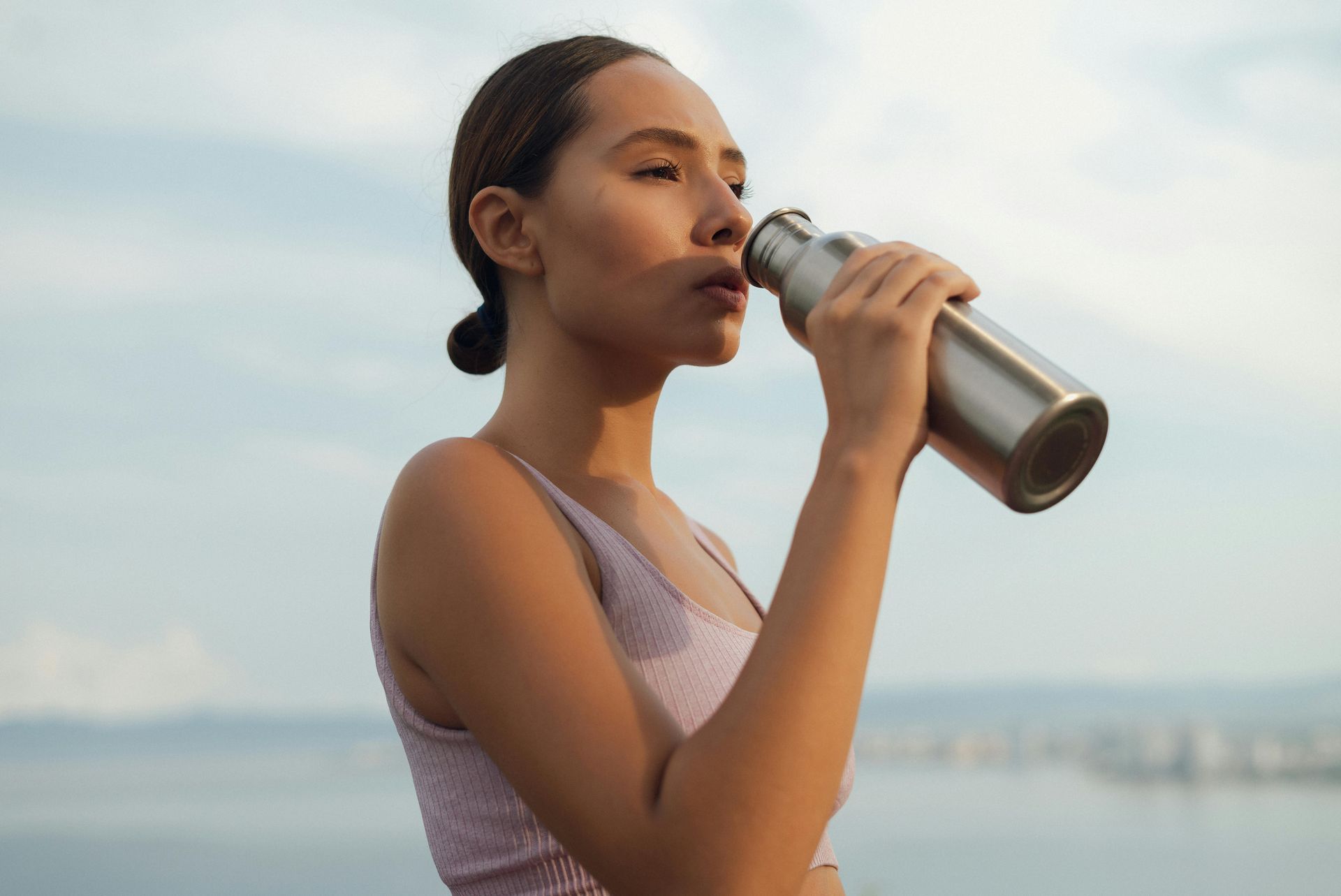 woman drinking water while exercising