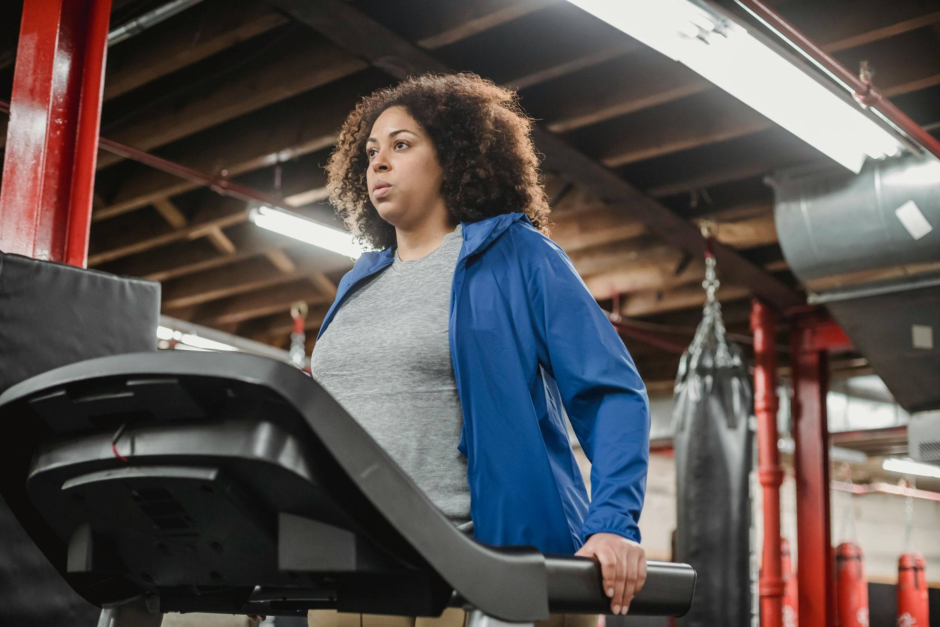 A woman is running on a treadmill in a gym.
