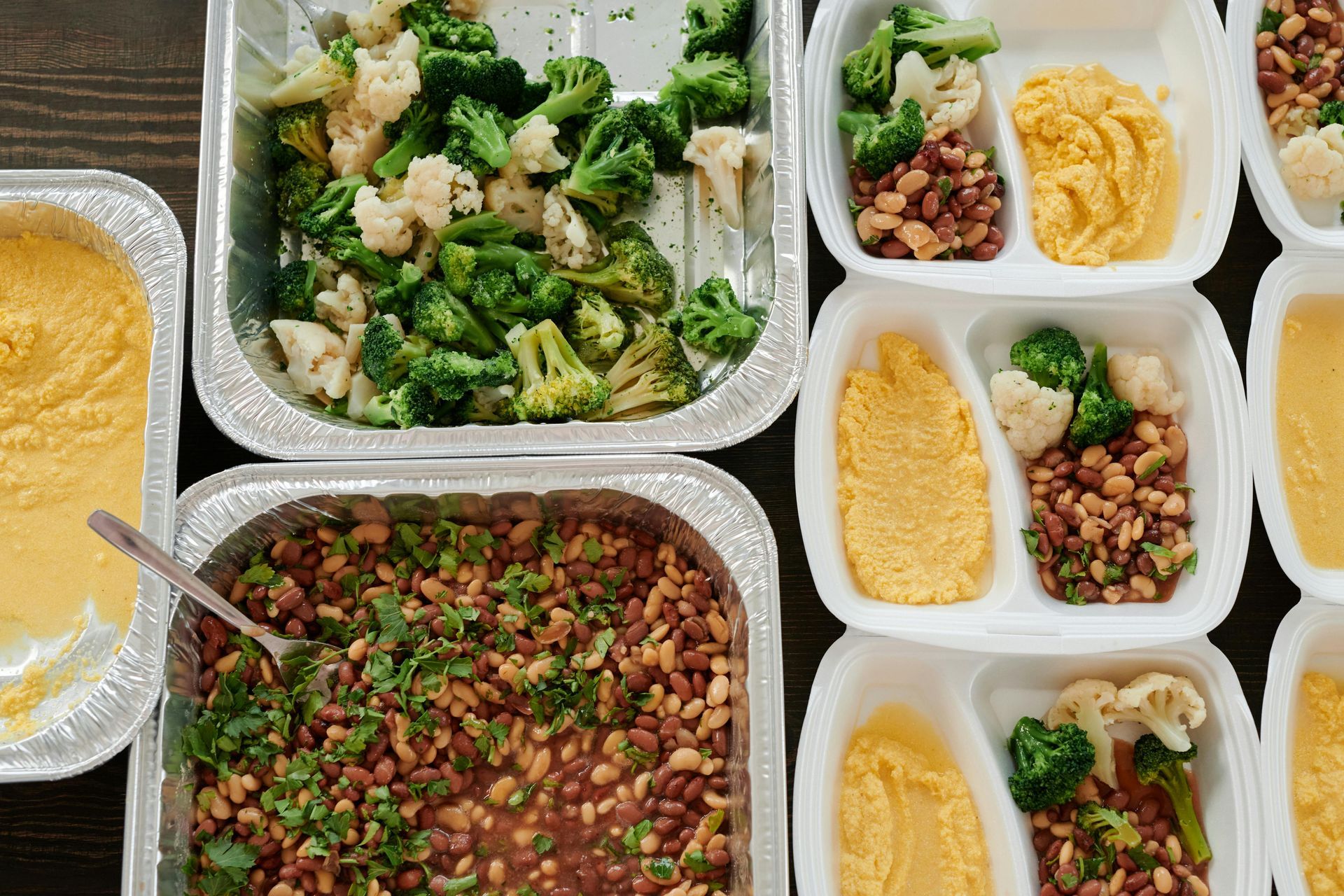 A table topped with a variety of containers of food.