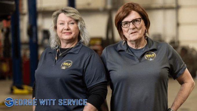 Two people in dark gray shirts standing in an industrial workshop, with a George Witt Services logo. | George Witt Service, Inc.