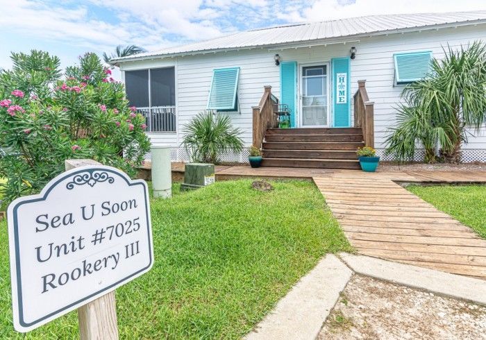 A house with a sign in front of it that says `` sea u soon unit # 7025 rookery iii ''.